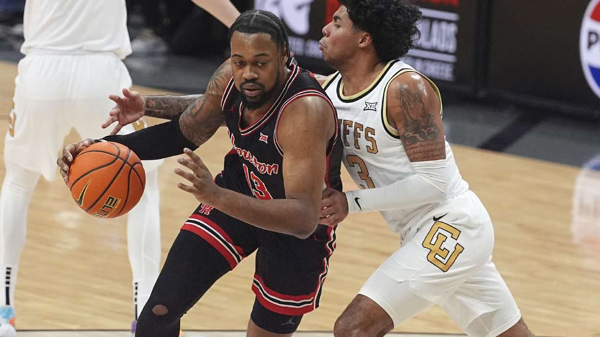 Houston forward J'Wan Roberts, left, drives past Colorado guard Julian Hammond III in the first half of an NCAA college basketball game Saturday, Feb. 8, 2025, in Boulder, Colo.
