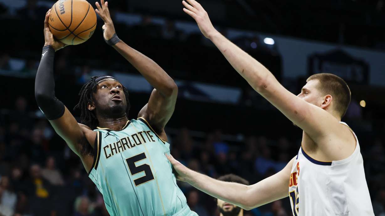 Charlotte Hornets center Mark Williams (5) looks to shoot against Denver Nuggets center Nikola Jokic, right, during the first half of an NBA basketball game in Charlotte, N.C., Saturday, Feb. 1, 2025.