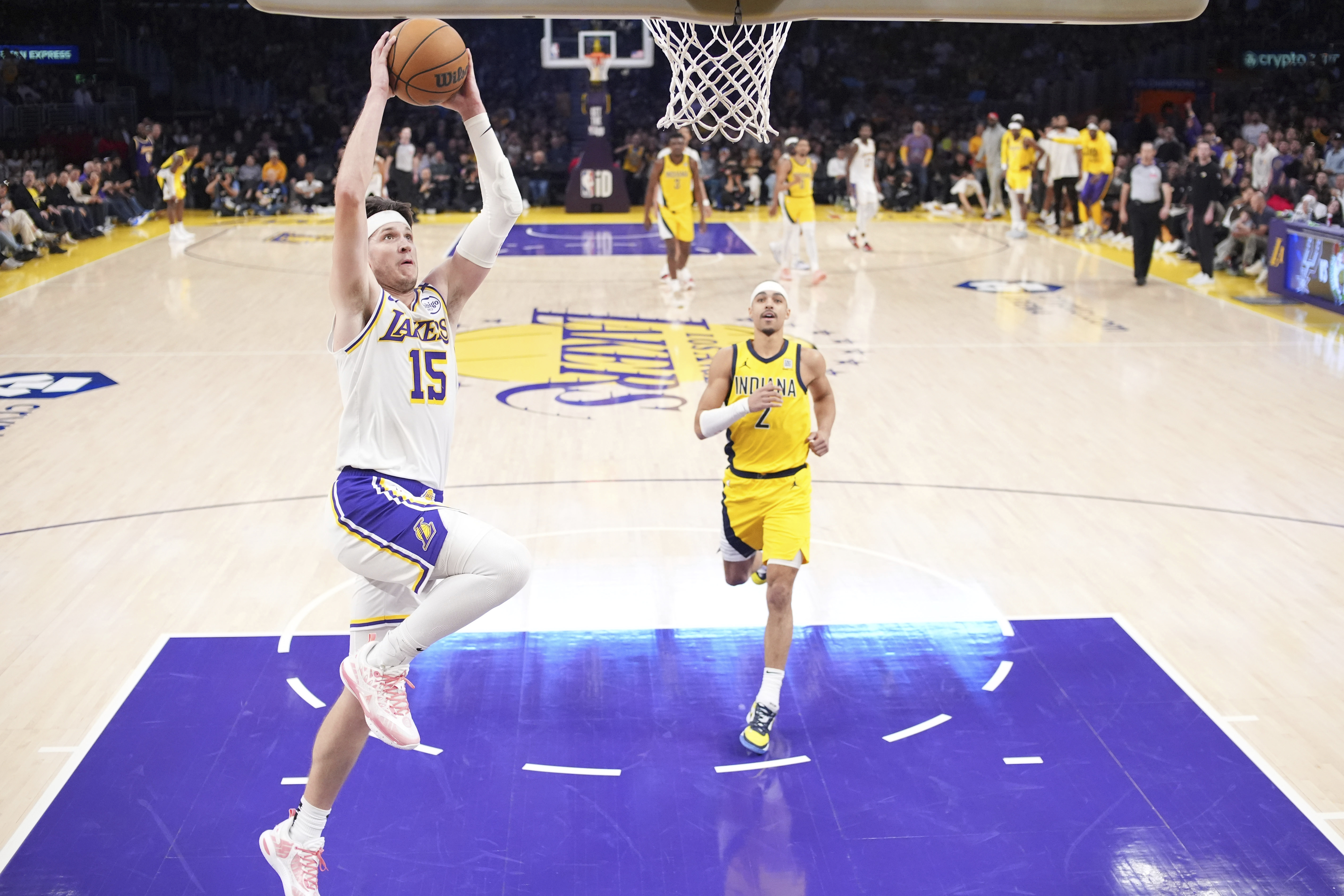 Los Angeles Lakers guard Austin Reaves, left, dunks as Indiana Pacers guard Andrew Nembhard watches during the second half of an NBA basketball game Saturday, Feb. 8, 2025, in Los Angeles.