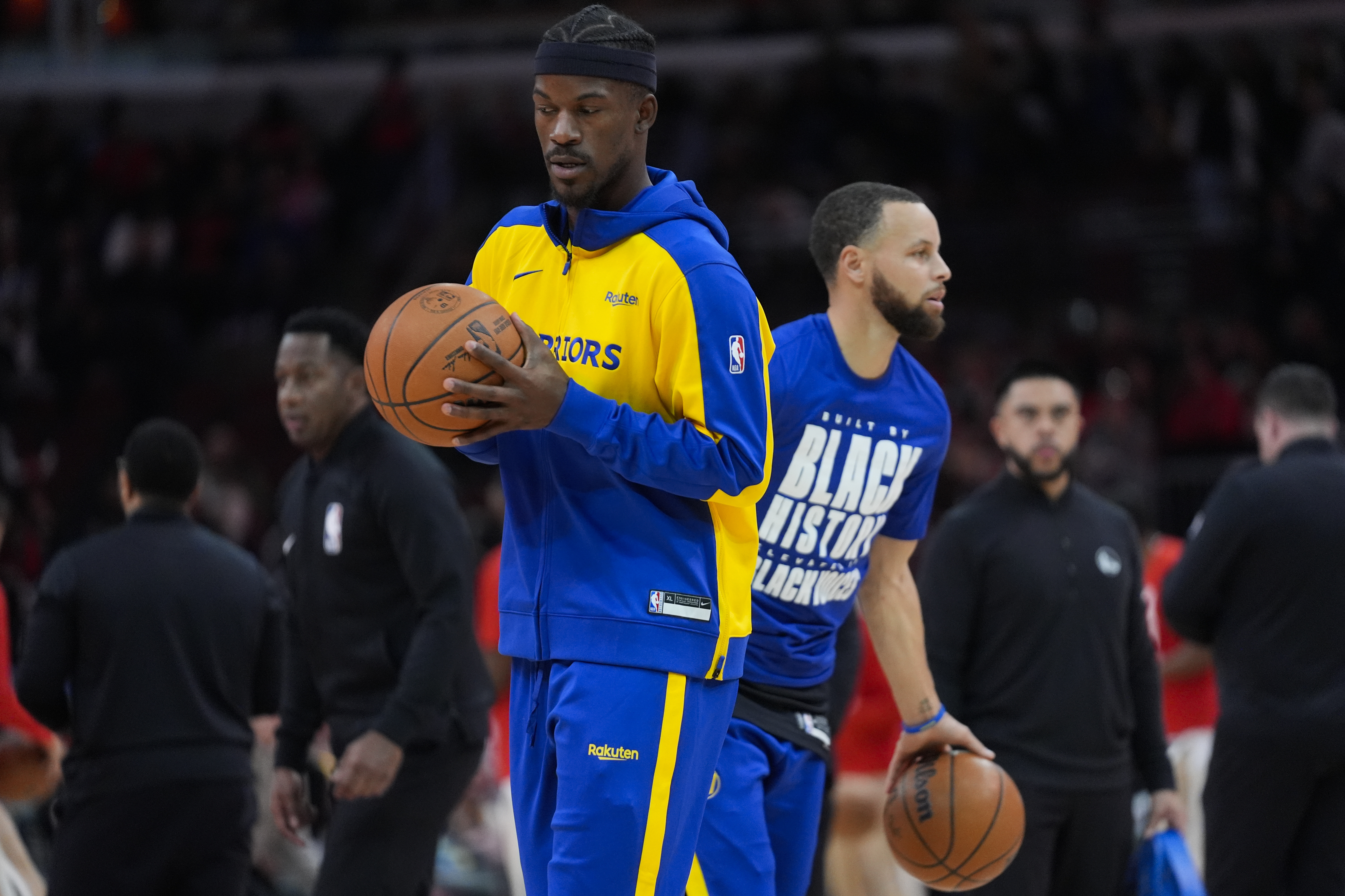 Golden State Warriors forward Jimmy Butler, left, and guard Stephen Curry, right, warm up before an NBA basketball game against the Chicago Bulls, Saturday, Feb. 8, 2025, in Chicago.
