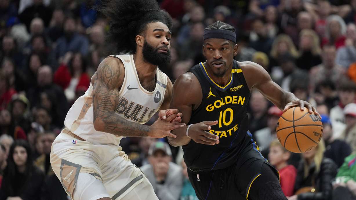 Chicago Bulls guard Coby White, left, guards against Golden State Warriors forward Jimmy Butler (10) during the second half of an NBA basketball game Saturday, Feb. 8, 2025, in Chicago.