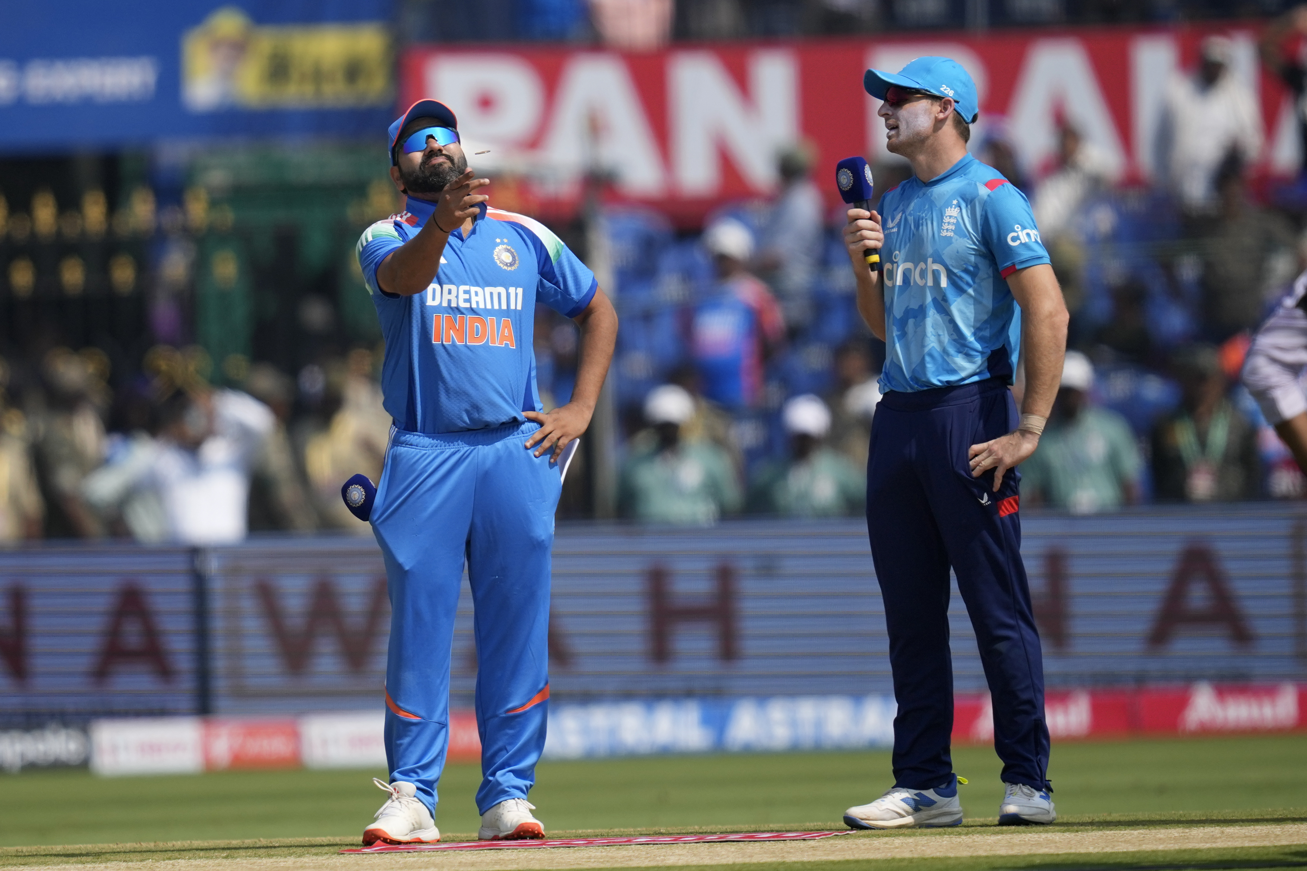 India's captain Rohit Sharma, left, flips the coins for toss as England's captain Jos Buttler watches before the start of the second one day international cricket match between India and England in Cuttack, India, Sunday, Feb. 9, 2025.