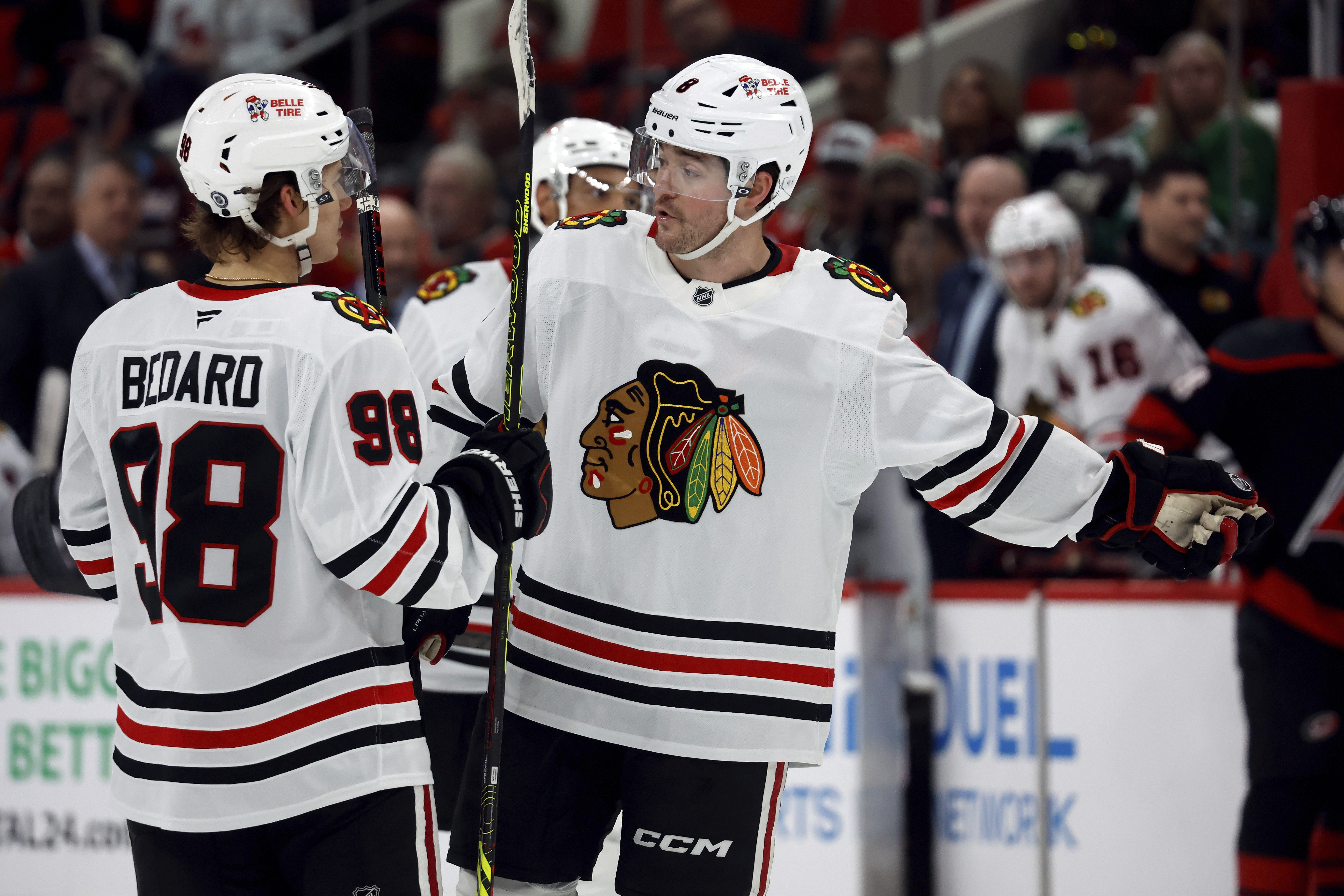 Chicago Blackhawks' Connor Bedard (98) discusses an upcoming face-off with teammate Ryan Donato (8) during the third period of an NHL hockey game against the Carolina Hurricanes in Raleigh, N.C., Thursday, Jan. 30, 2025.