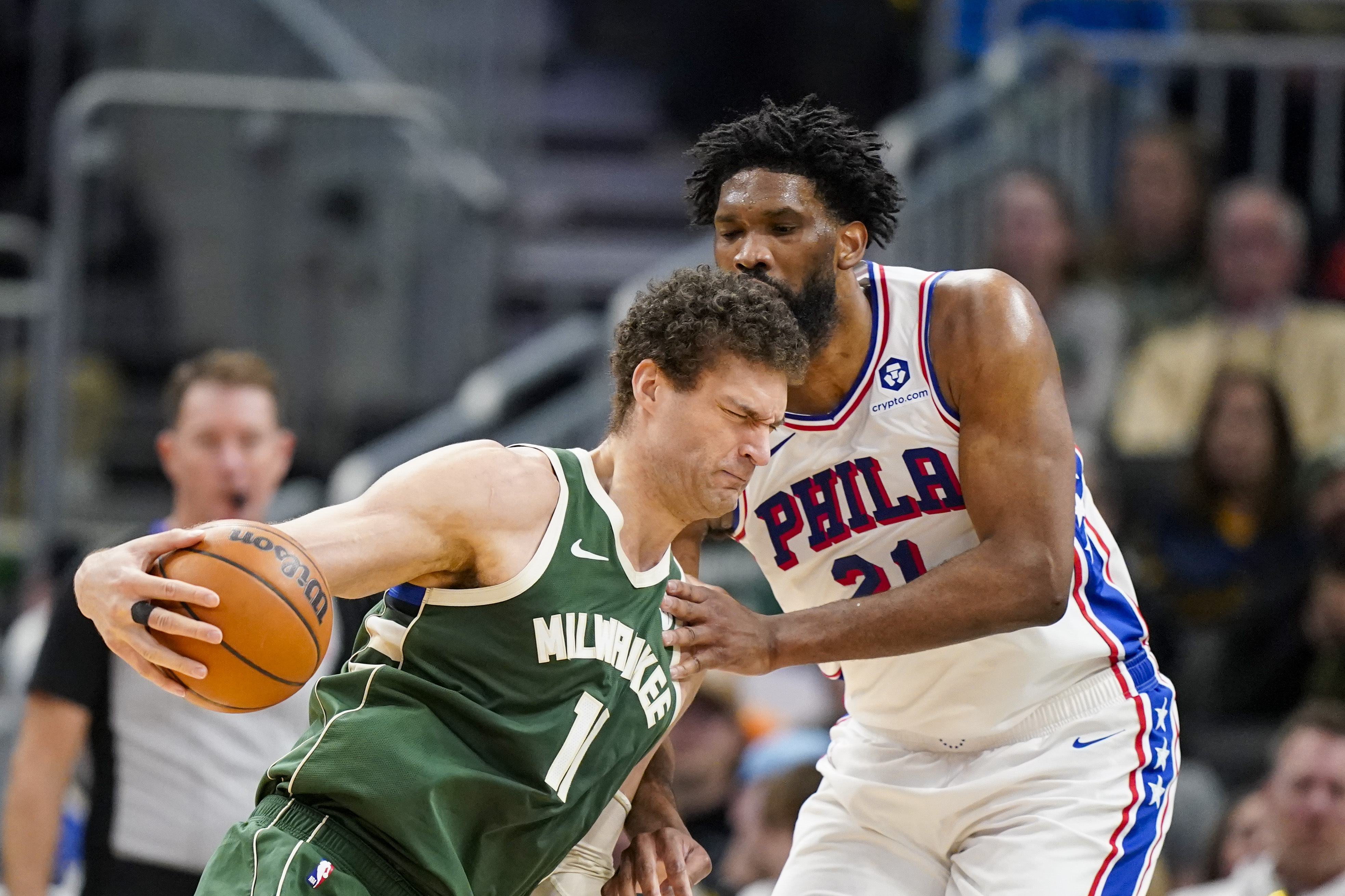 Milwaukee Bucks' Brook Lopez, left, drives against Philadelphia 76ers' Joel Embiid, right, during the first half of an NBA basketball game Sunday, Feb. 9, 2025, in Milwaukee.