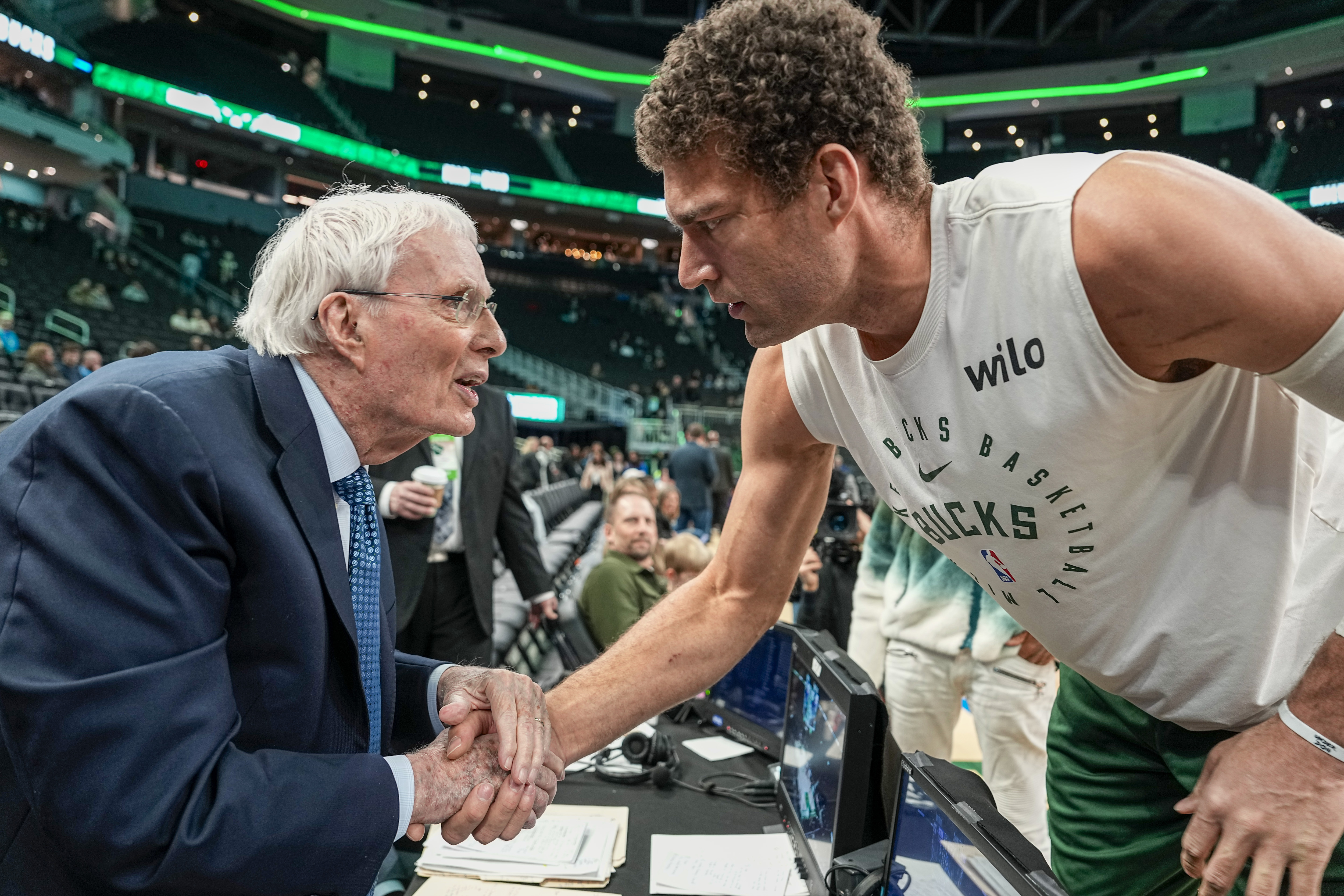 Milwaukee Bucks' Brook Lopez, right, talks with ESPN and ABC broadcaster Hubie Brown, left, on Brown's final game before an NBA basketball game between the Bucks and the Philadelphia 76ers, Sunday, Feb. 9, 2025, in Milwaukee.