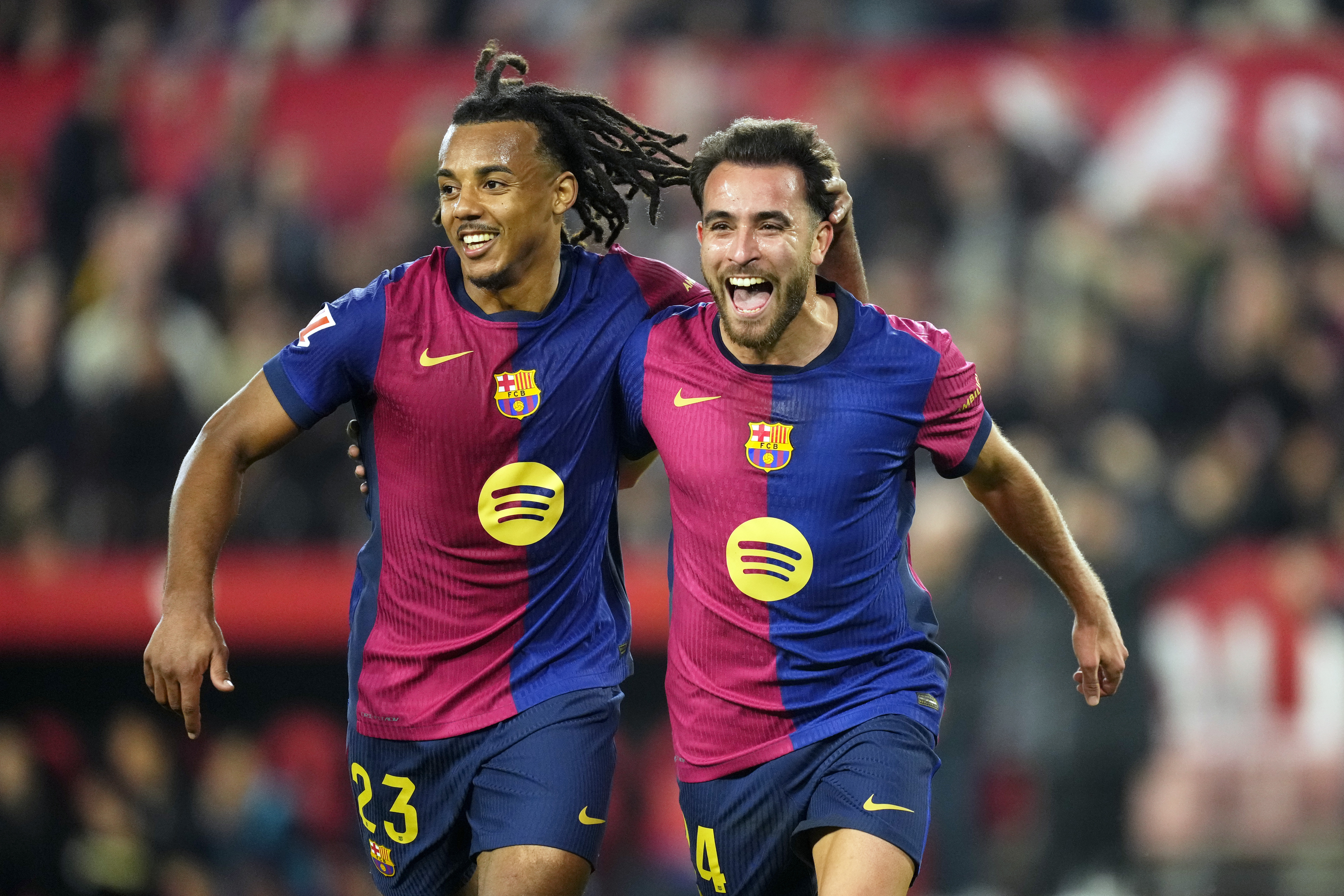Barcelona's Eric Garcia celebrates with Jules Kounde, left, after scoring his side's fourth goal during a Spanish La Liga soccer match between Sevilla and FC Barcelona at the Ramon Sanchez Pizjuan stadium in Seville, Spain, Sunday, Feb. 9, 2025.