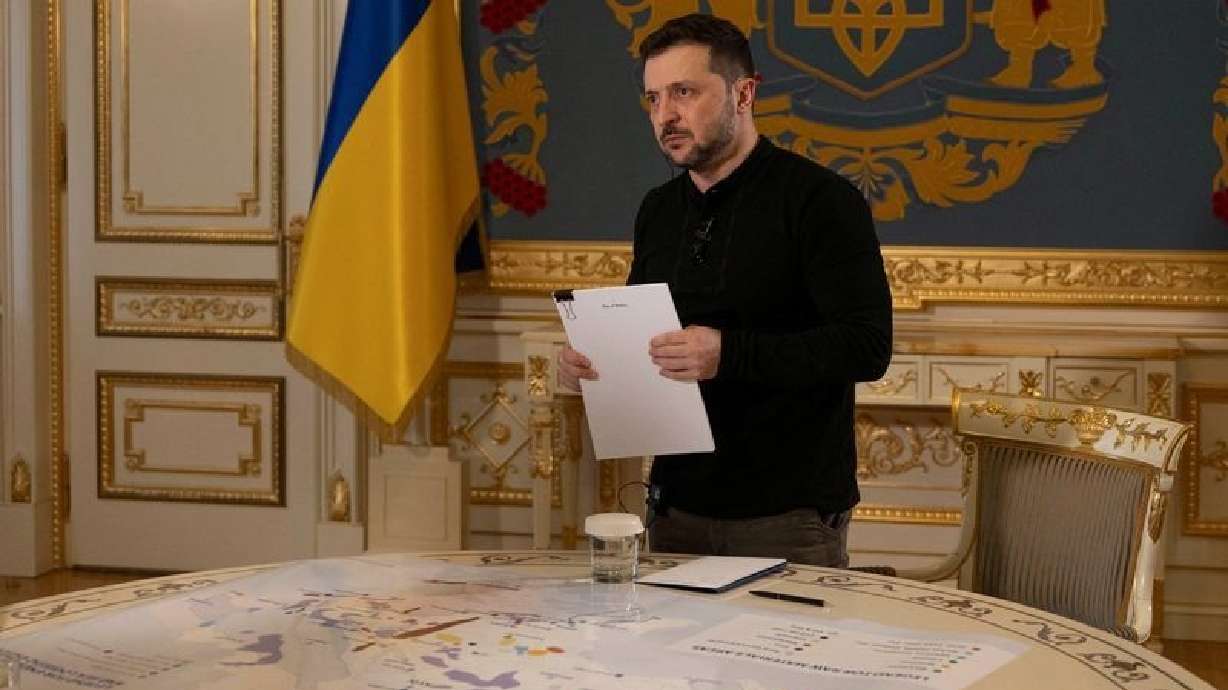 Ukraine's President Volodymyr Zelenskyy holds a the Plan of Victory next to a map of strategic resources and objects during an interview with Reuters, amid Russia's attack on Ukraine, in Kyiv, Ukraine Feb. 7.