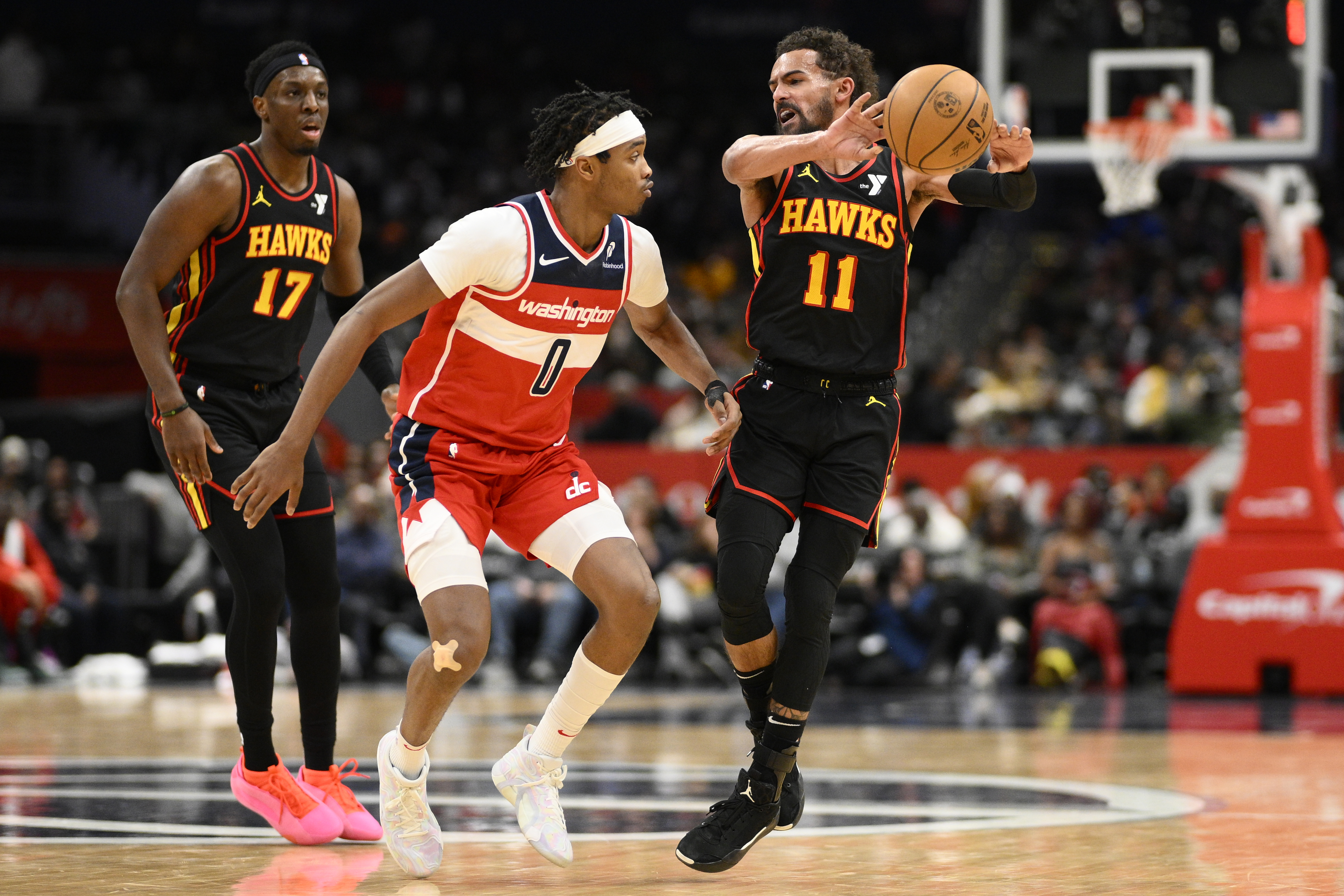 Atlanta Hawks guard Trae Young (11) passes the ball against Washington Wizards guard Bilal Coulibaly (0) during the second half of an NBA basketball game, Saturday, Feb. 8, 2025, in Washington.