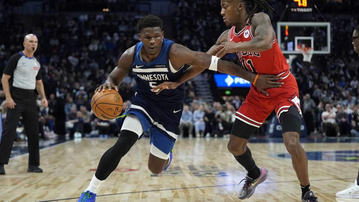 Minnesota Timberwolves guard Anthony Edwards (5) works toward the basket as Chicago Bulls guard Ayo Dosunmu (11) defends during the first half of an NBA basketball game, Wednesday, Feb. 5, 2025, in Minneapolis.