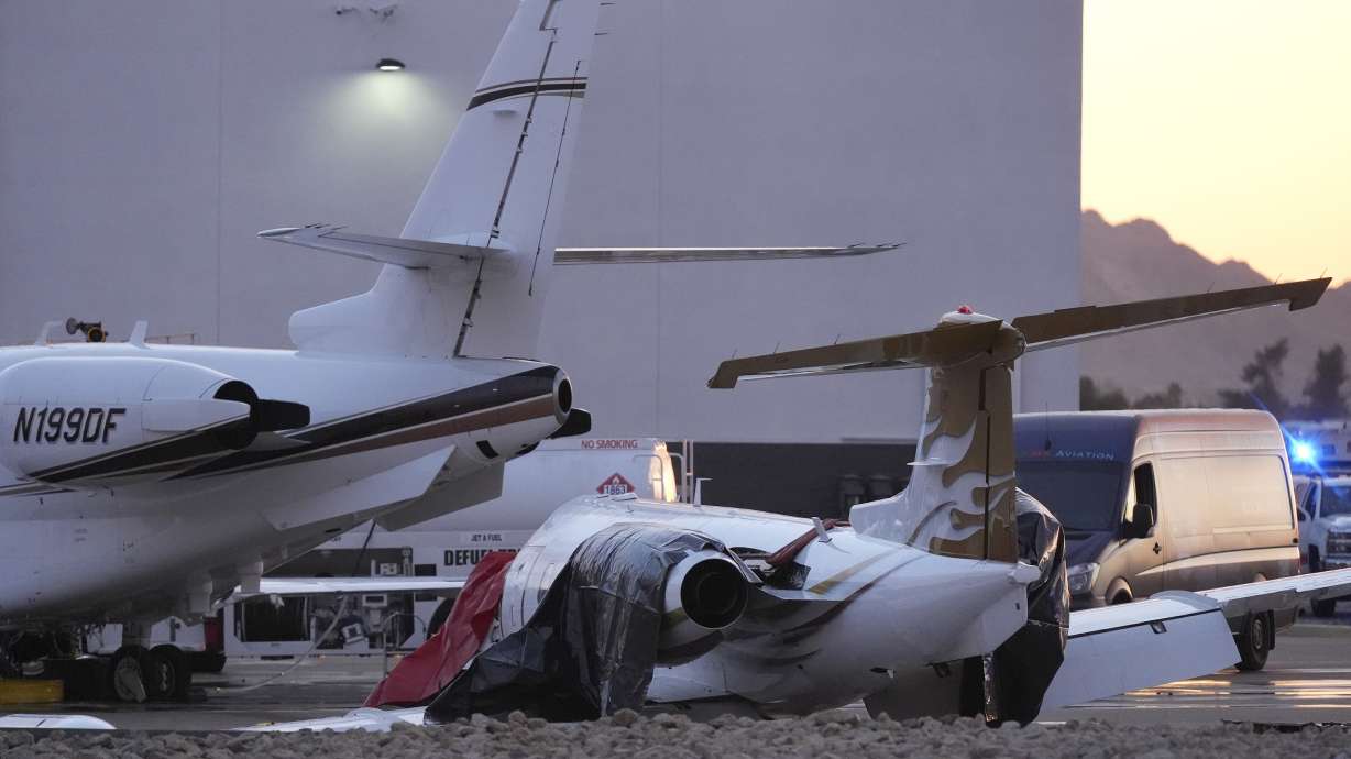 A crashed Learjet, right, sits damaged after colliding with another plane at Scottsdale Airport Monday, in Scottsdale, Ariz.