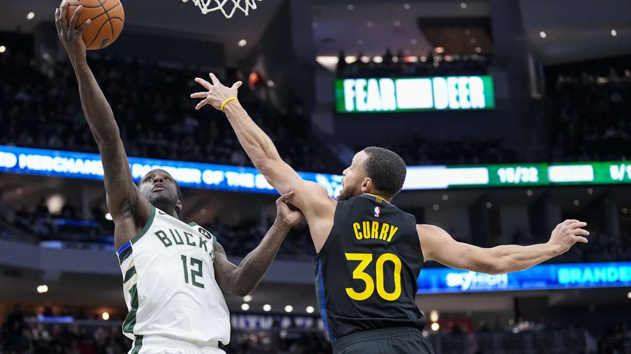 Milwaukee Bucks' Taurean Prince (12) looks to shoot against Golden State Warriors' Stephen Curry (30) during the first half of an NBA basketball game Monday, Feb. 10, 2025, in Milwaukee.