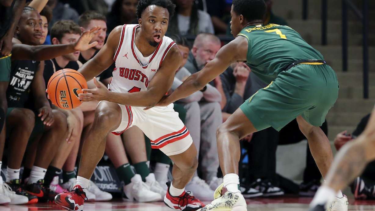 Houston guard L.J. Cryer, left, drives around Baylor guard V.J. Edgecombe (7) during the first half of an NCAA college basketball game Monday, Feb. 10, 2025, in Houston.