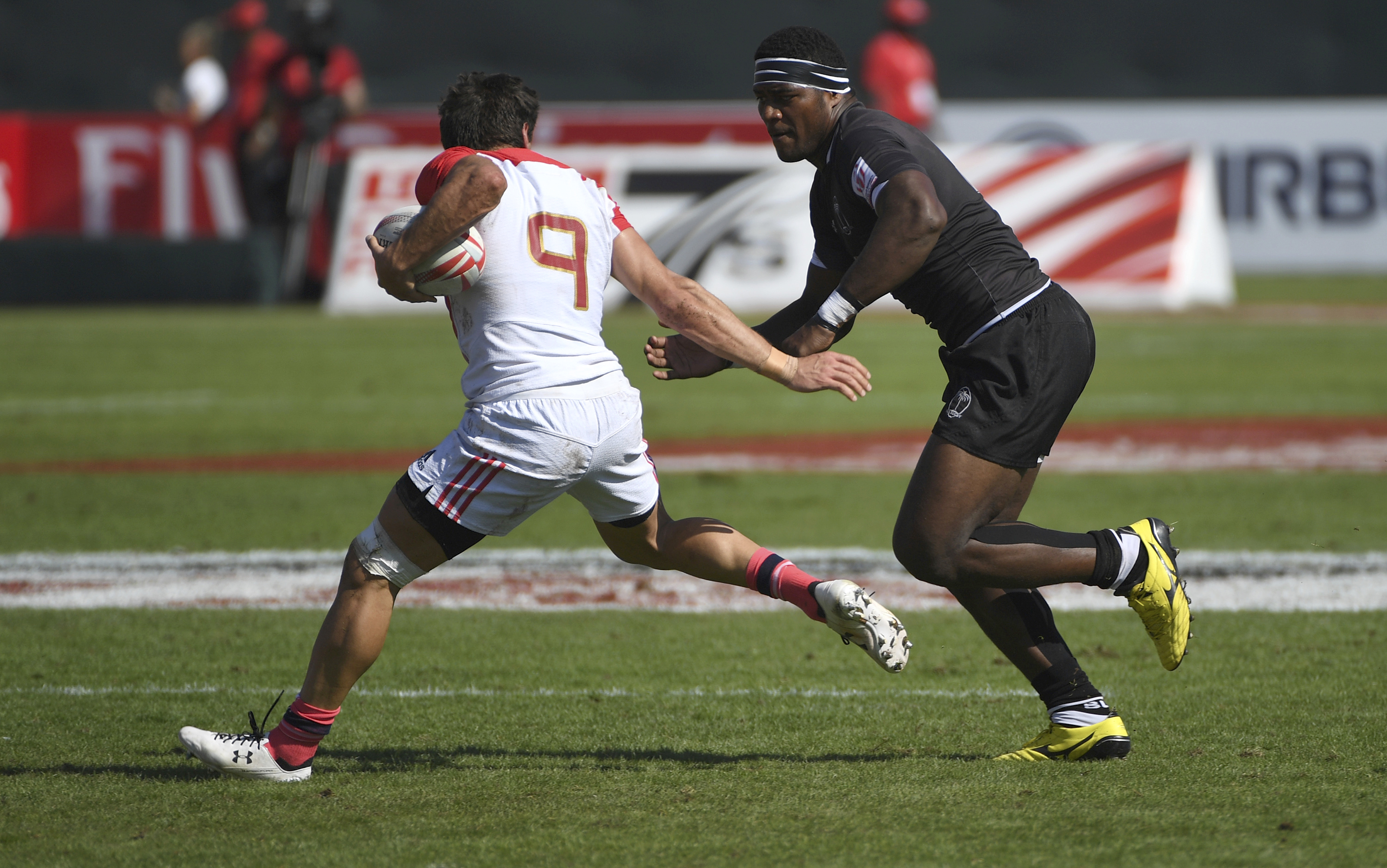 FILE - France's Jeremy Aicardi, left, tries to avoid a tackle by Fiji's Masivesi Dakuwaqa in their quarterfinal match of the World Rugby Sevens Series in Dubai, the United Arab Emirates, on Dec. 3, 2016.