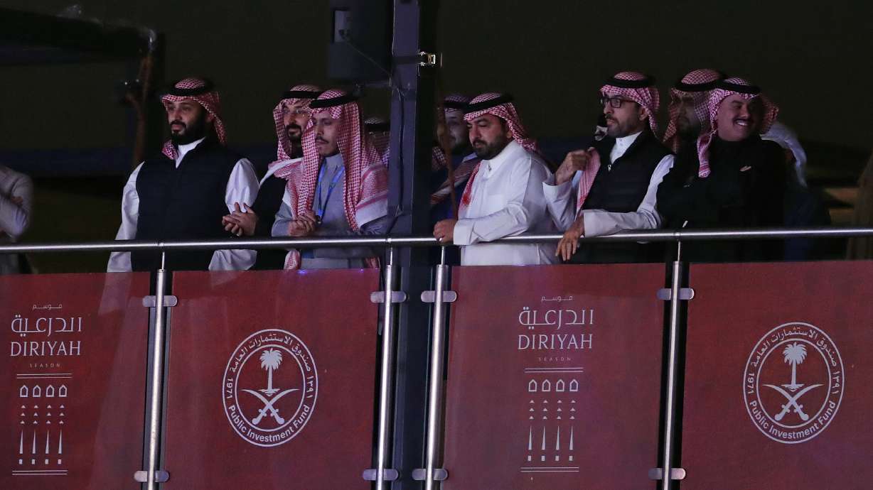 FILE - Saudi Crown Prince Mohammed bin Salman, left, watches as defending champion Andy Ruiz Jr. fights Britain's Anthony Joshua in a World Heavyweight Championship boxing contest at the Diriyah Arena, Riyadh, Saudi Arabia on Dec. 8, 2019.