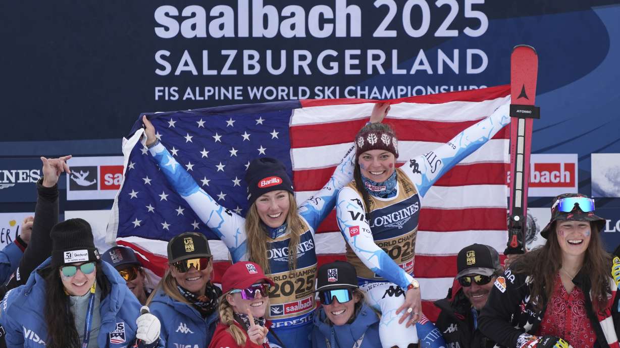 United States' Mikaela Shiffrin, left, and United States' Breezy Johnson, celebrate on the podium with the team after winning the gold medal in a women's team combined event, at the Alpine Ski World Championships, in Saalbach-Hinterglemm, Austria, Tuesday, Feb. 11, 2025.