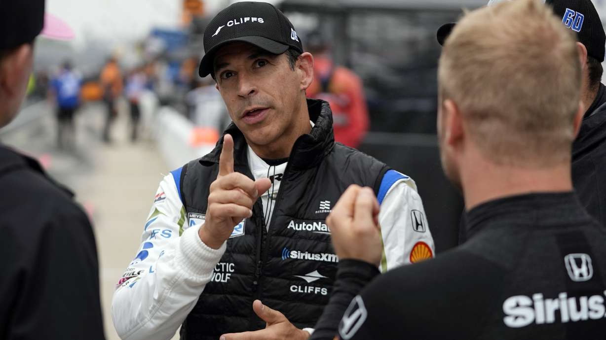 FILE - Helio Castroneves, of Brazil, talks with other drivers during a practice session for the Indianapolis 500 auto race at Indianapolis Motor Speedway, Tuesday, May 14, 2024, in Indianapolis.