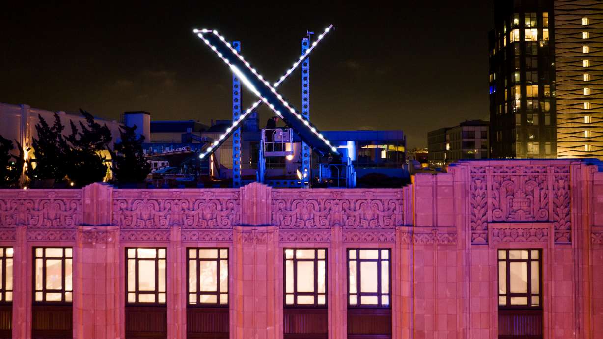 Workers install lighting on an "X" sign atop the company headquarters, formerly known as Twitter, in downtown San Francisco, July 28, 2023.