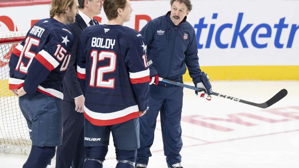 Guy Gaudreau, right, the father of the late Johnny and Matthew Gaudreau joins U.S.A. team players Noah Hanifin (15) and Matt Boldy (12) on the ice during 4 Nations Face-Off hockey practice in Montreal, Tuesday, Feb. 11, 2025.