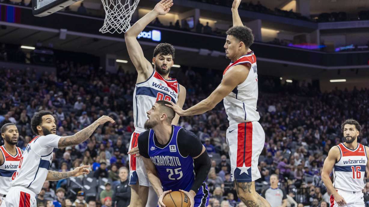 Sacramento Kings center Alex Len (25) draws the foul on Washington Wizards guard Johnny Davis, right, during the second half of an NBA basketball game Sunday, Jan. 19, 2025, in Sacramento, Calif.
