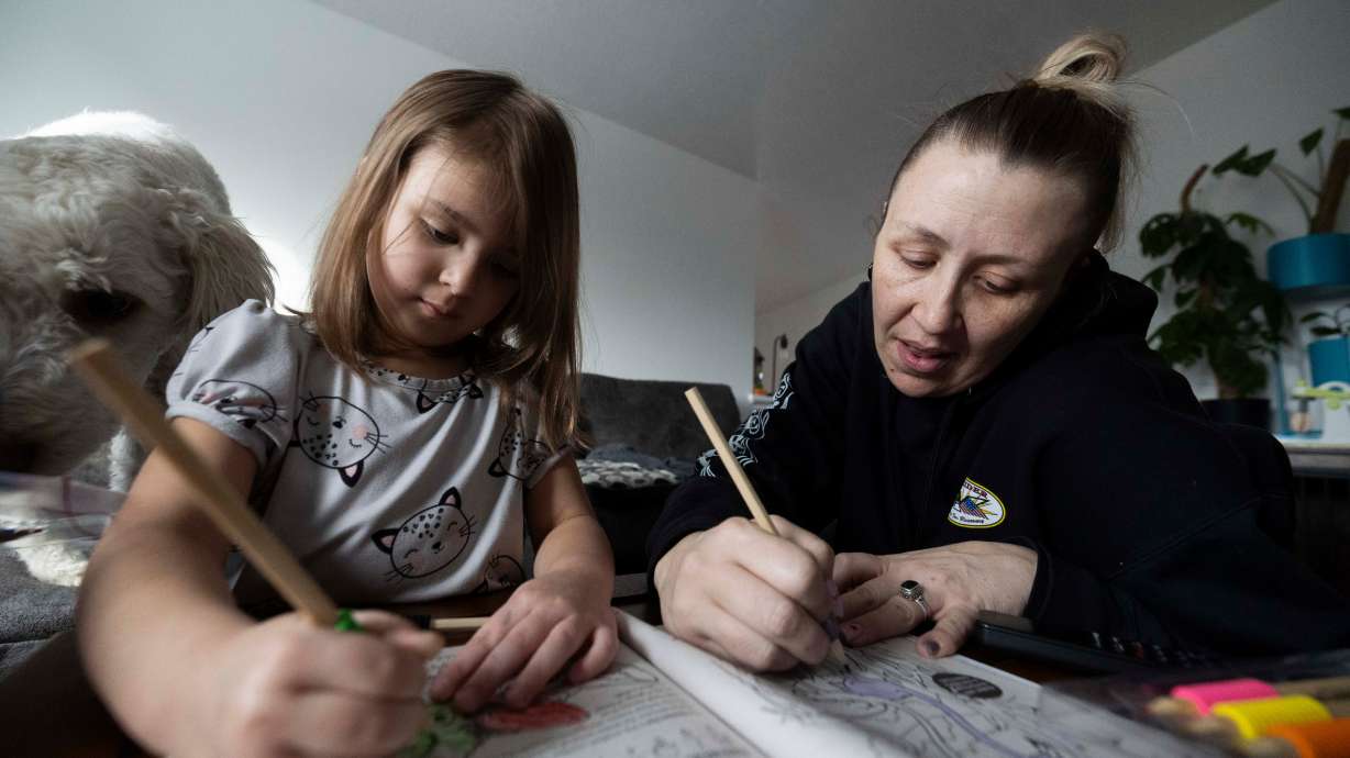 Amelia Diaz, 4, left, and her mother Emily Diaz, right, at their home in Midvale on Tuesday. Over the last few years, the Diaz family has experienced an increase in income, which has highlighted the difficulties of transitioning away from welfare benefits.