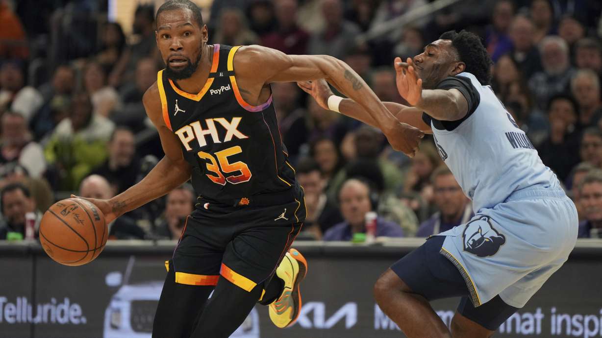 Phoenix Suns forward Kevin Durant (35) drives on Memphis Grizzlies guard Vince Williams Jr. during the first half of an NBA basketball game, Tuesday, Feb. 11, 2025, in Phoenix.
