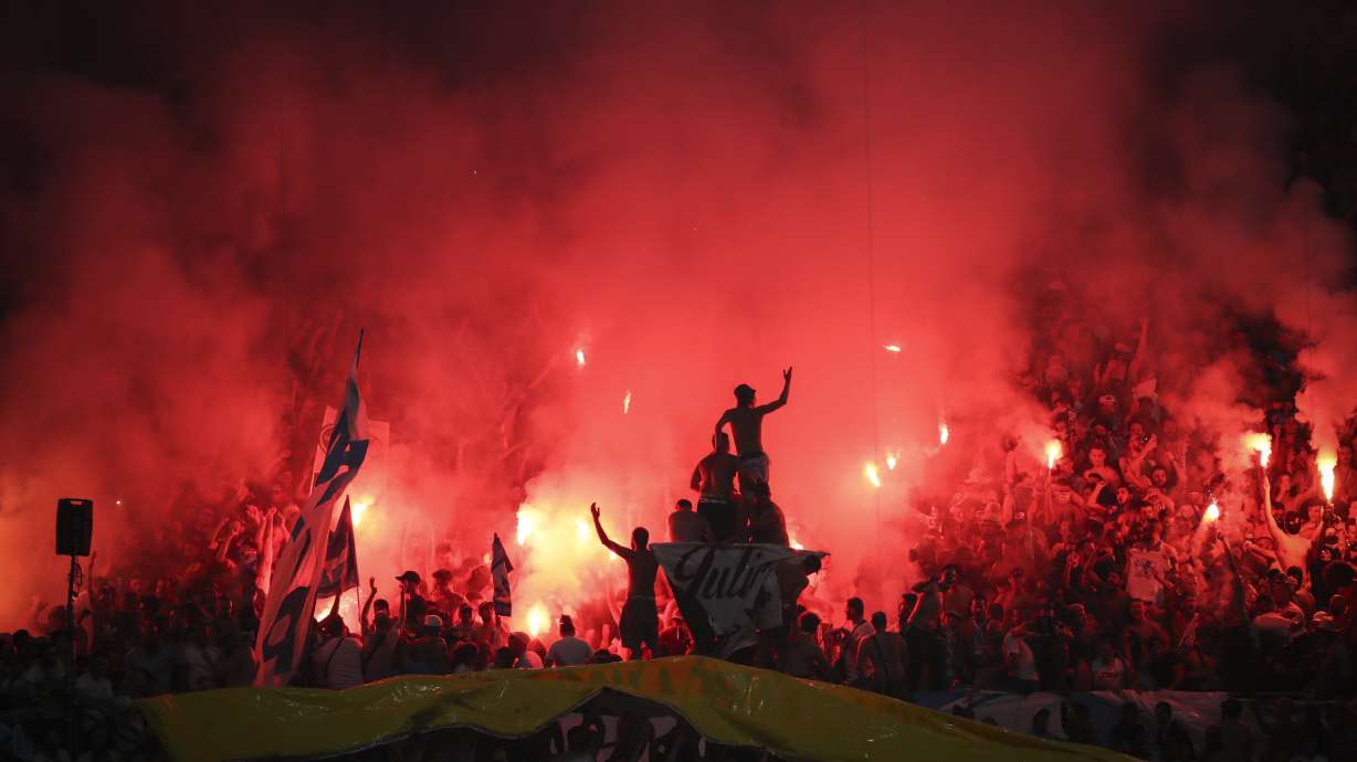 FILE - Marseille fans light flares during the French League One soccer match between Marseille and Saint-Etienne at the Velodrome stadium in Marseille, southern France, Sunday, Sept. 1, 2019.