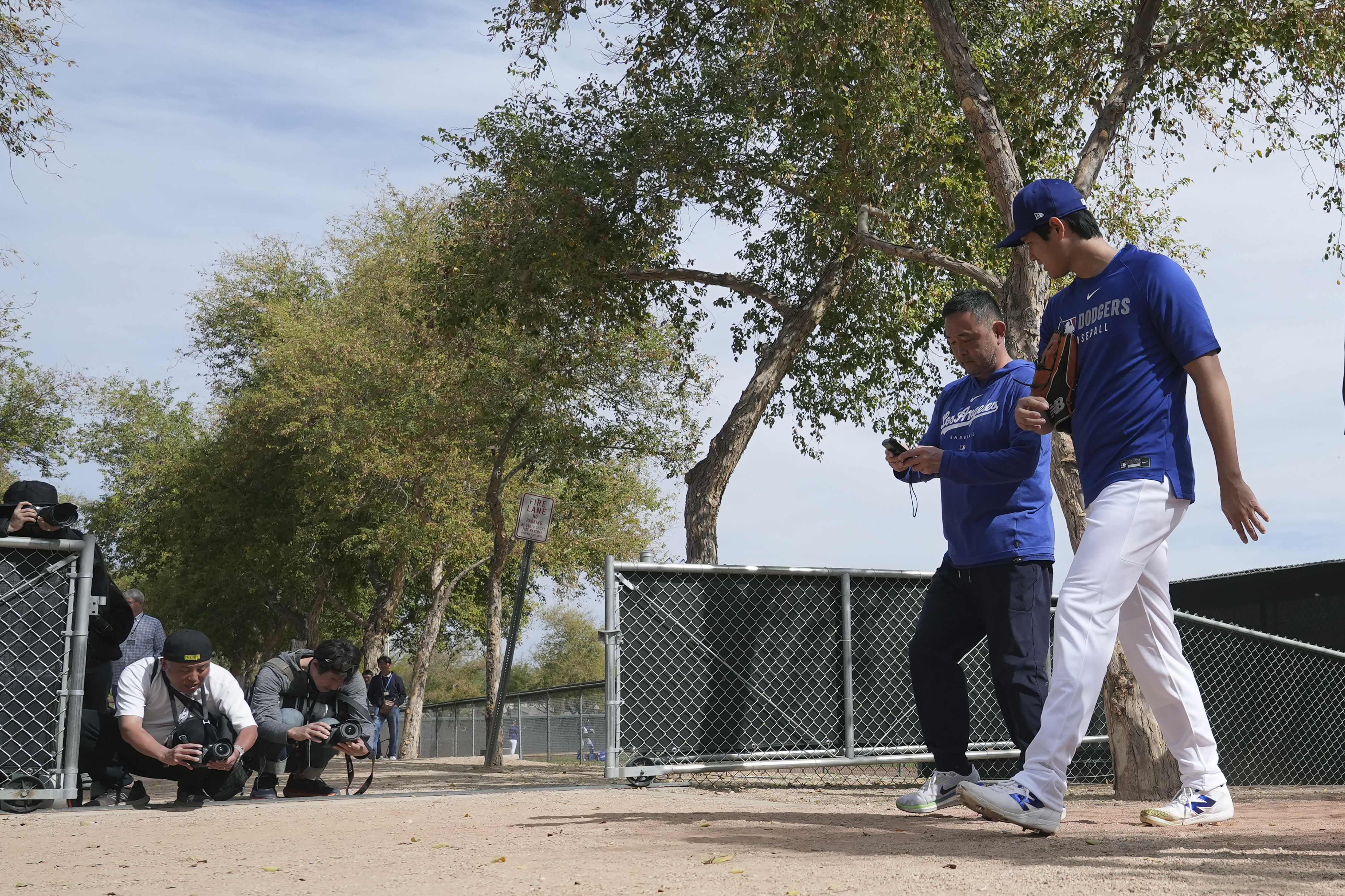 Los Angeles Dodgers' Shohei Ohtani, right, of Japan, walks back to the clubhouse at the Dodgers baseball spring training facility after working out Tuesday, Feb. 11, 2025, in Phoenix.