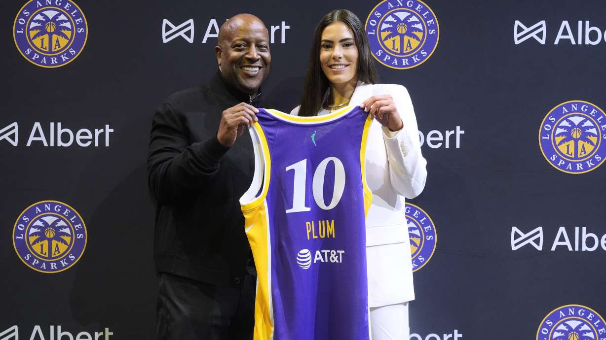 Los Angeles Sparks' Kelsey Plum, right, poses with her jersey with Sparks CEO Eric Holoman during an introductory WNBA basketball press conference, Wednesday, Feb. 12, 2025, in Los Angeles.