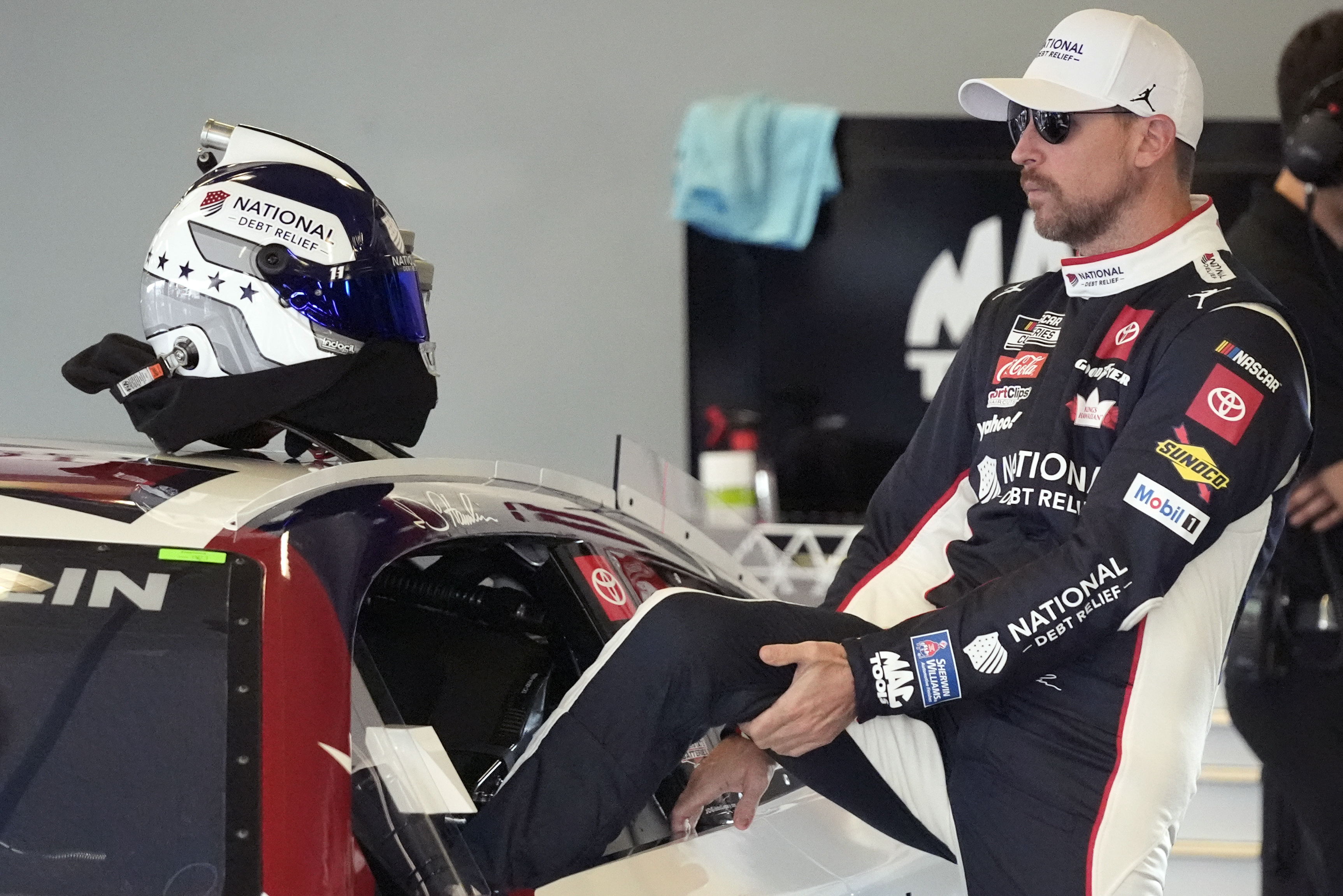Denny Hamlin climbs into his car during a practice session for the NASCAR Daytona 500 auto race at Daytona International Speedway, Wednesday, Feb. 12, 2025, in Daytona Beach, Fla.