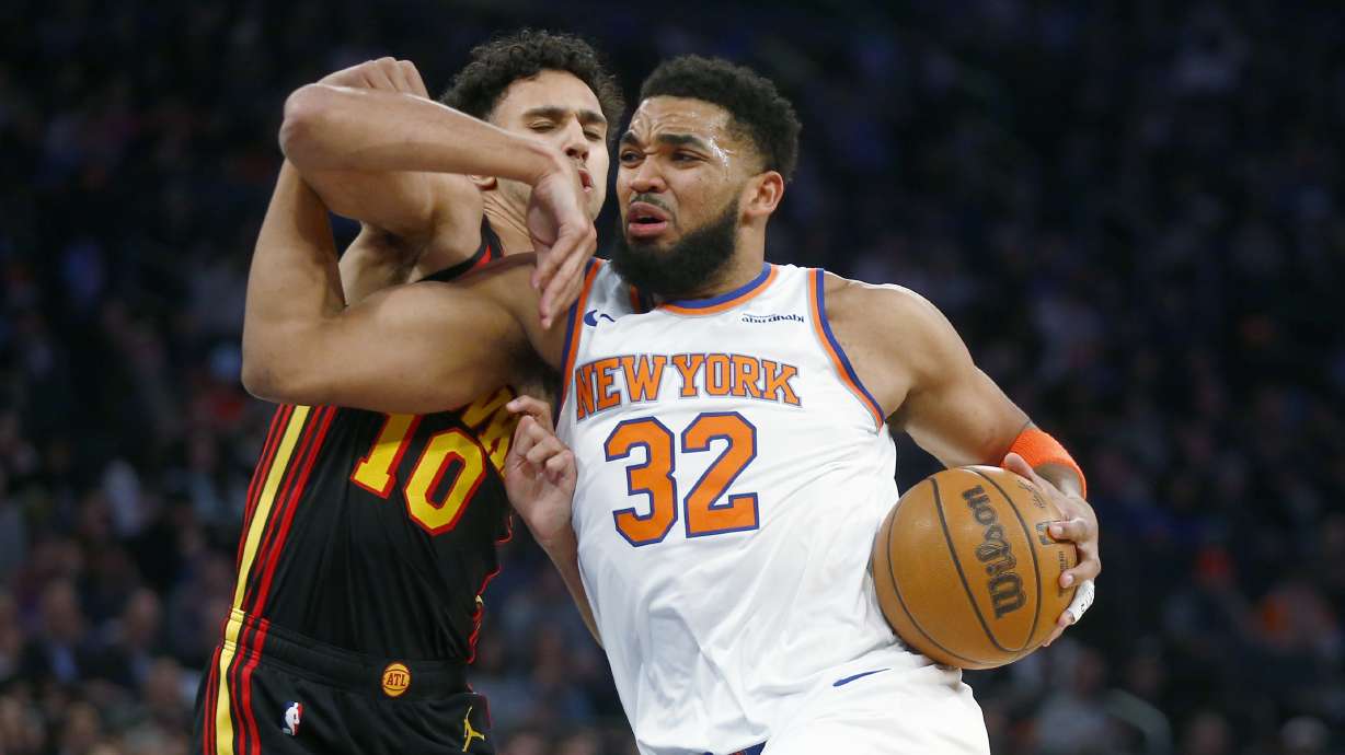 New York Knicks center Karl-Anthony Towns (32) drives past Atlanta Hawks forward Zaccharie Risacher (10) during the first half of an NBA basketball game Wednesday, Feb. 12, 2025, in New York.