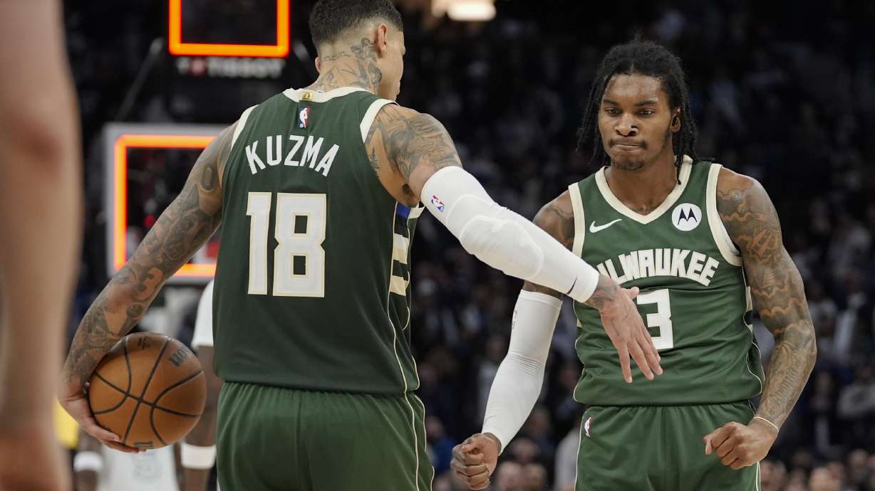 Milwaukee Bucks forward Kyle Kuzma (18) and guard Kevin Porter Jr. (3) celebrate as time expires during an NBA basketball game against the Minnesota Timberwolves, Wednesday, Feb. 12, 2025, in Minneapolis.