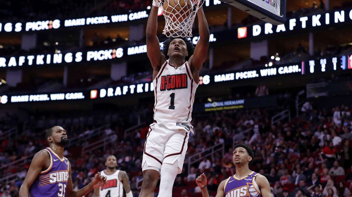 Houston Rockets forward Amen Thompson (1) dunks between Phoenix Suns forwards Kevin Durant (35) and Ryan Dunn (0) during the first half of an NBA basketball game Wednesday, Feb. 12, 2025, in Houston.