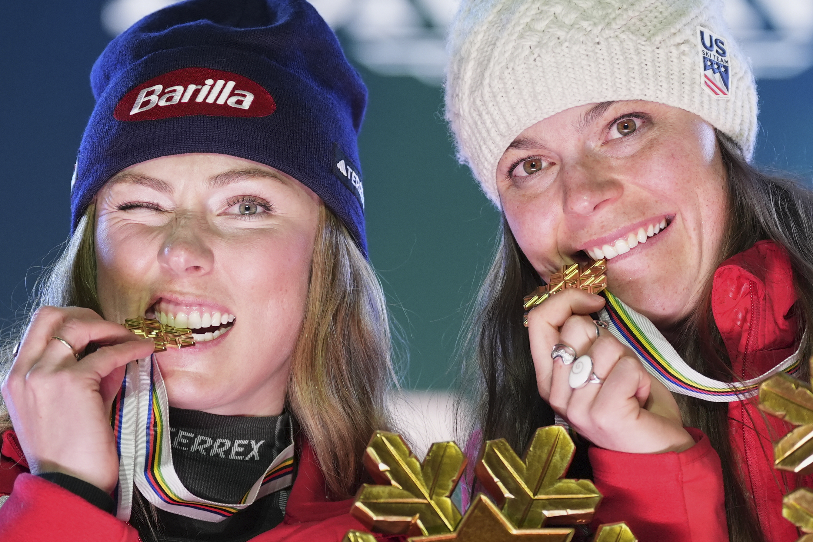 United States' Mikaela Shiffrin, left, and United States' Breezy Johnson bite their gold medals for a women's team combined event, at the Alpine Ski World Championships, in Saalbach-Hinterglemm, Austria, Tuesday, Feb. 11, 2025.