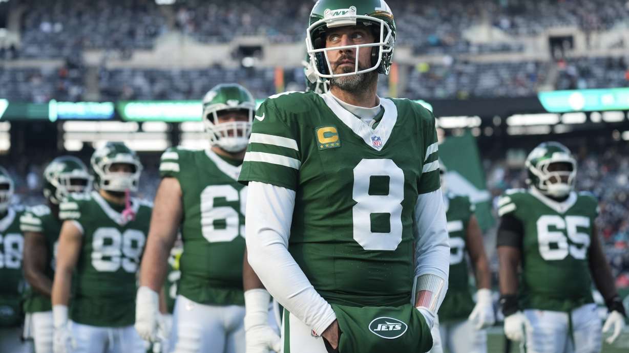 FILE - New York Jets quarterback Aaron Rodgers (8) stands with teammates before an NFL football game against the Miami Dolphins, Jan. 5, 2025, in East Rutherford, N.J.