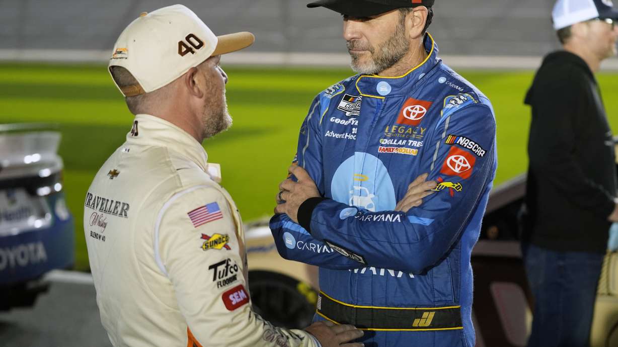 Justin Allgaier, left, and Jimmie Johnson talk on the pit road during qualifying for the NASCAR Daytona 500 auto race at Daytona International Speedway, Wednesday, Feb. 12, 2025, in Daytona Beach, Fla.