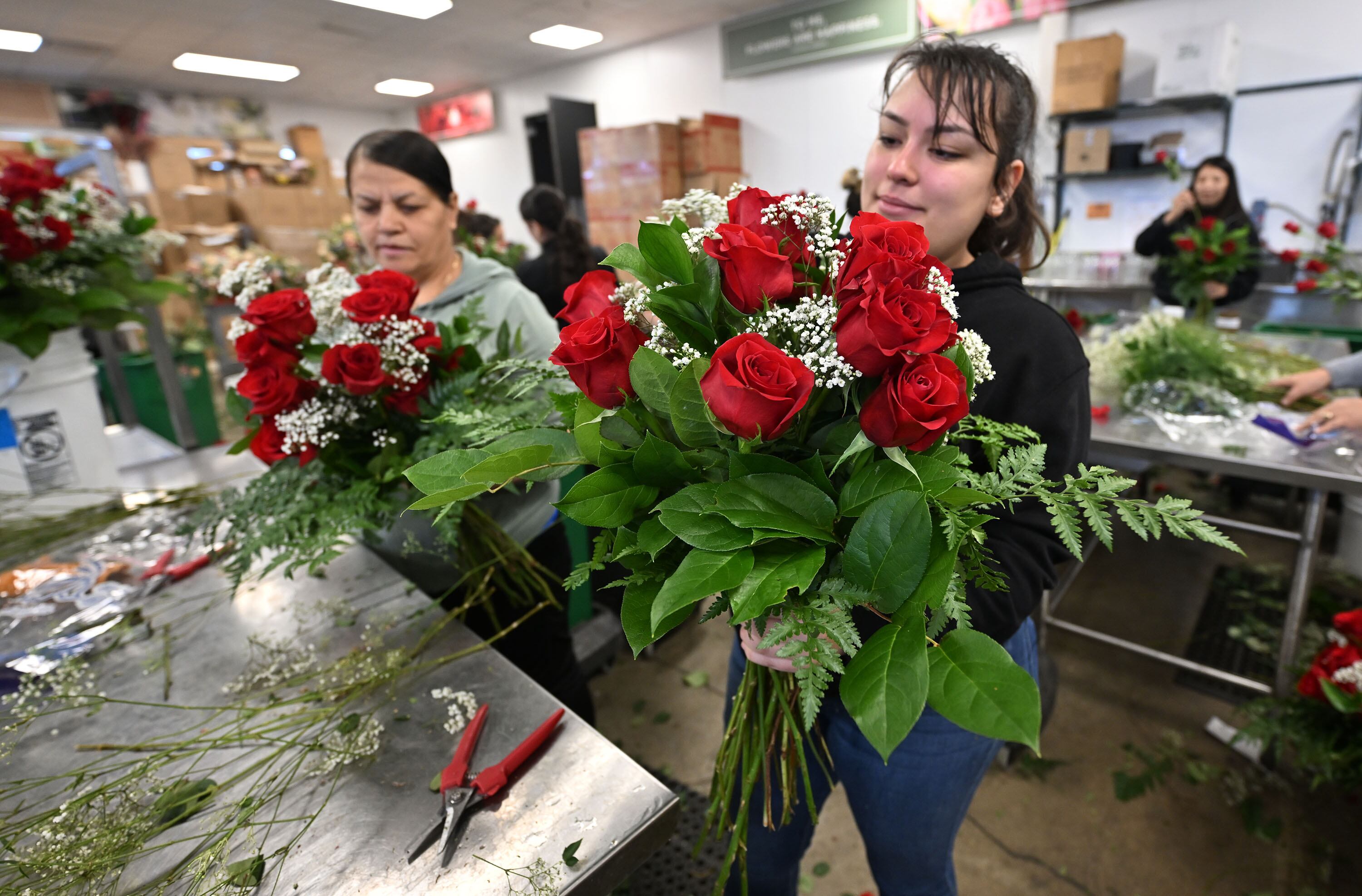 Patricia Jimenez and Adamaris Reynaga create beautiful arrangements along with others at Harmons Floral in West Valley on Tuesday.