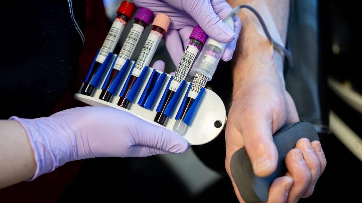 Collection Specialist 2 Kiera Parsons, left, injects Troy Vellinga’s donated blood into test tubes at the American Red Cross Blood Donation Center in Murray on Jan. 26.