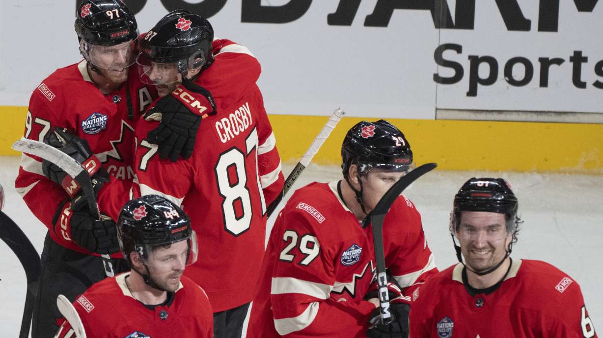 Canada's Connor McDavid (97) and Sidney Crosby (87) hug following their overtime win over Sweden during 4 Nations Face-Off hockey game in Montreal, Wednesday, Feb. 12, 2025.