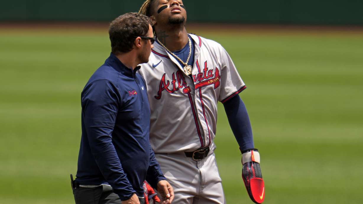 FILE - Atlanta Braves' Ronald Acuña Jr., right, walks off the field with a trainer after being injured while running the bases during the first inning of a baseball game against the Pittsburgh Pirates in Pittsburgh, Sunday, May 26, 2024.