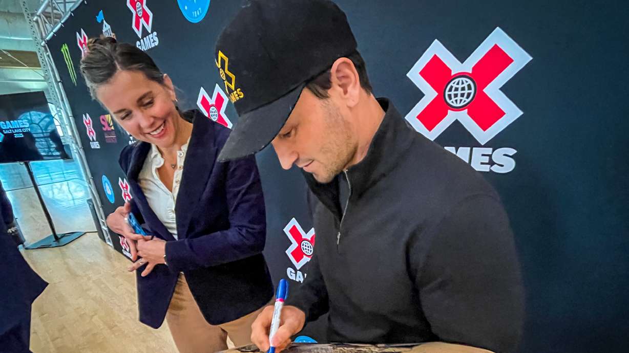 X Games CEO Jeremy Bloom signs a Salt Lake City-themed skateboard deck for Salt Lake City Mayor Erin Mendenhall after a press conference Thursday announcing X Games will come to Salt Lake City at the Utah State Fairpark in June.
