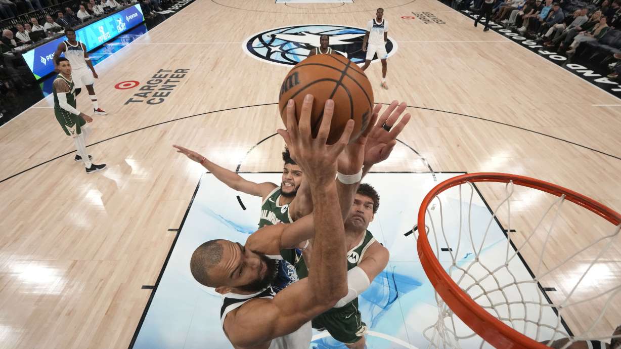 Minnesota Timberwolves center Rudy Gobert (27) goes up for a shot as Milwaukee Bucks guard Andre Jackson Jr. (44), back left, and center Brook Lopez (11), right, defend during the second half of an NBA basketball game, Wednesday, Feb. 12, 2025, in Minneapolis.