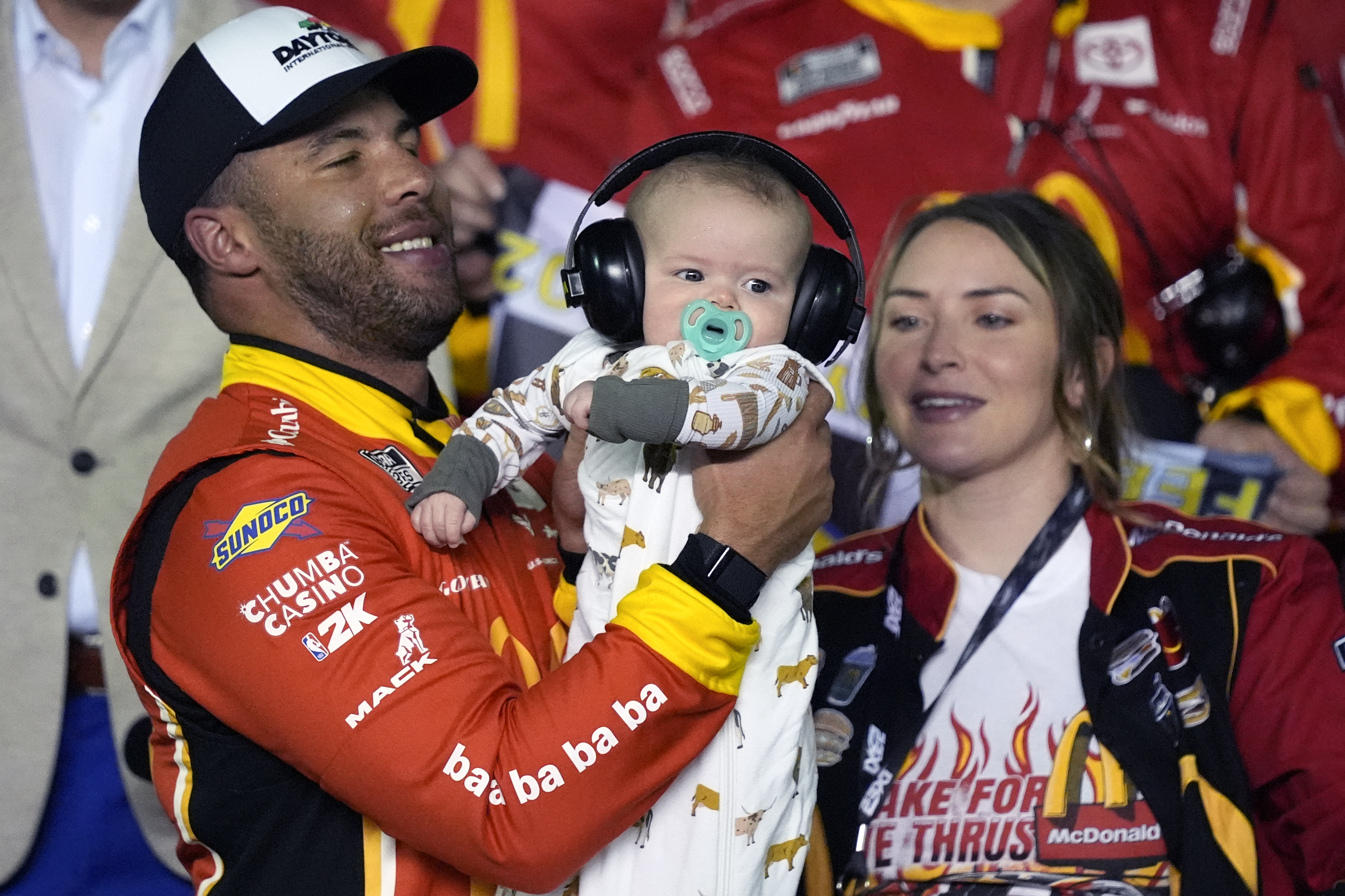 Bubba Wallace , left, celebrates in Victory lane with his son Becks Hayden and his wife Amanda Carter after winning the first of two NASCAR Daytona 500 qualifying auto races at Daytona International Speedway, Thursday, Feb. 13, 2025, in Daytona Beach, Fla.