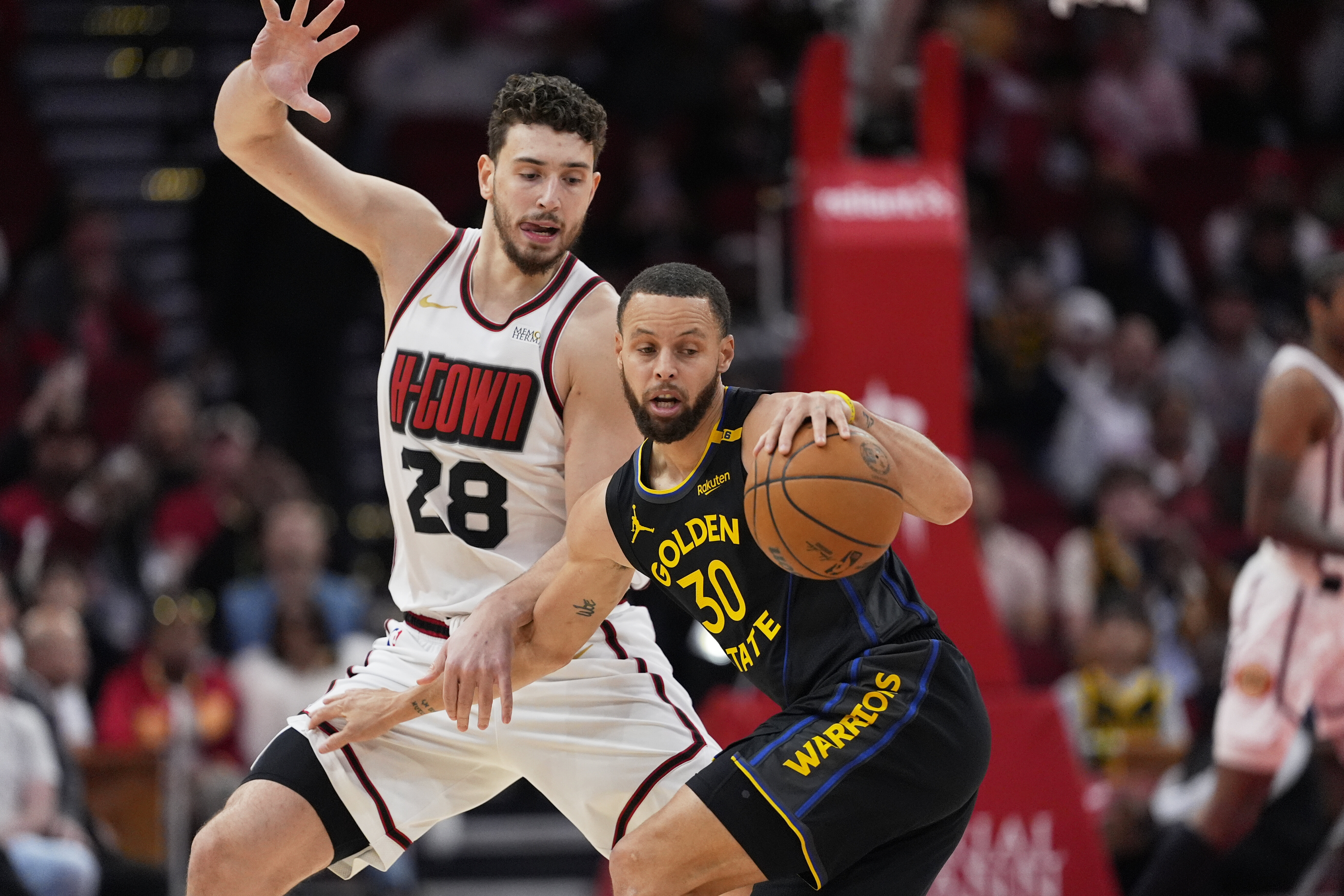 Houston Rockets' Alperen Sengun (28) defends against Golden State Warriors' Stephen Curry (30) during the first half of an NBA basketball game Thursday, Feb. 13, 2025, in Houston.