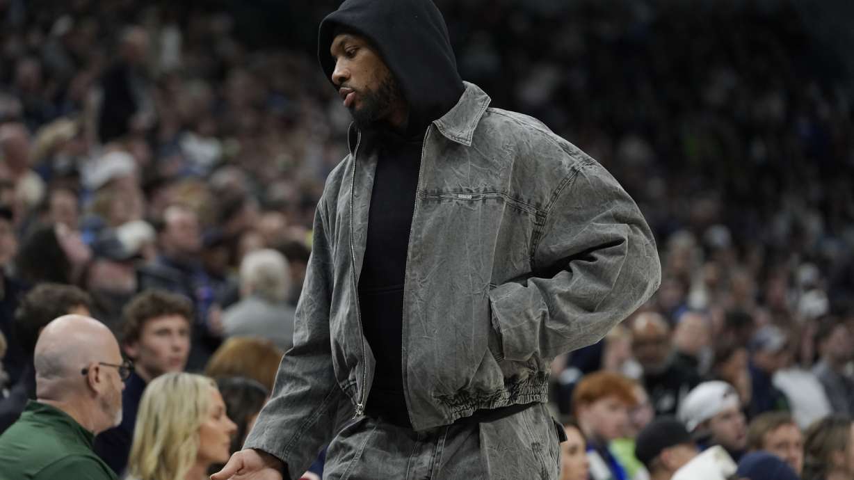 Milwaukee Bucks guard Damian Lillard walks along the team bench during the first half of an NBA basketball game against the Minnesota Timberwolves, Wednesday, Feb. 12, 2025, in Minneapolis.