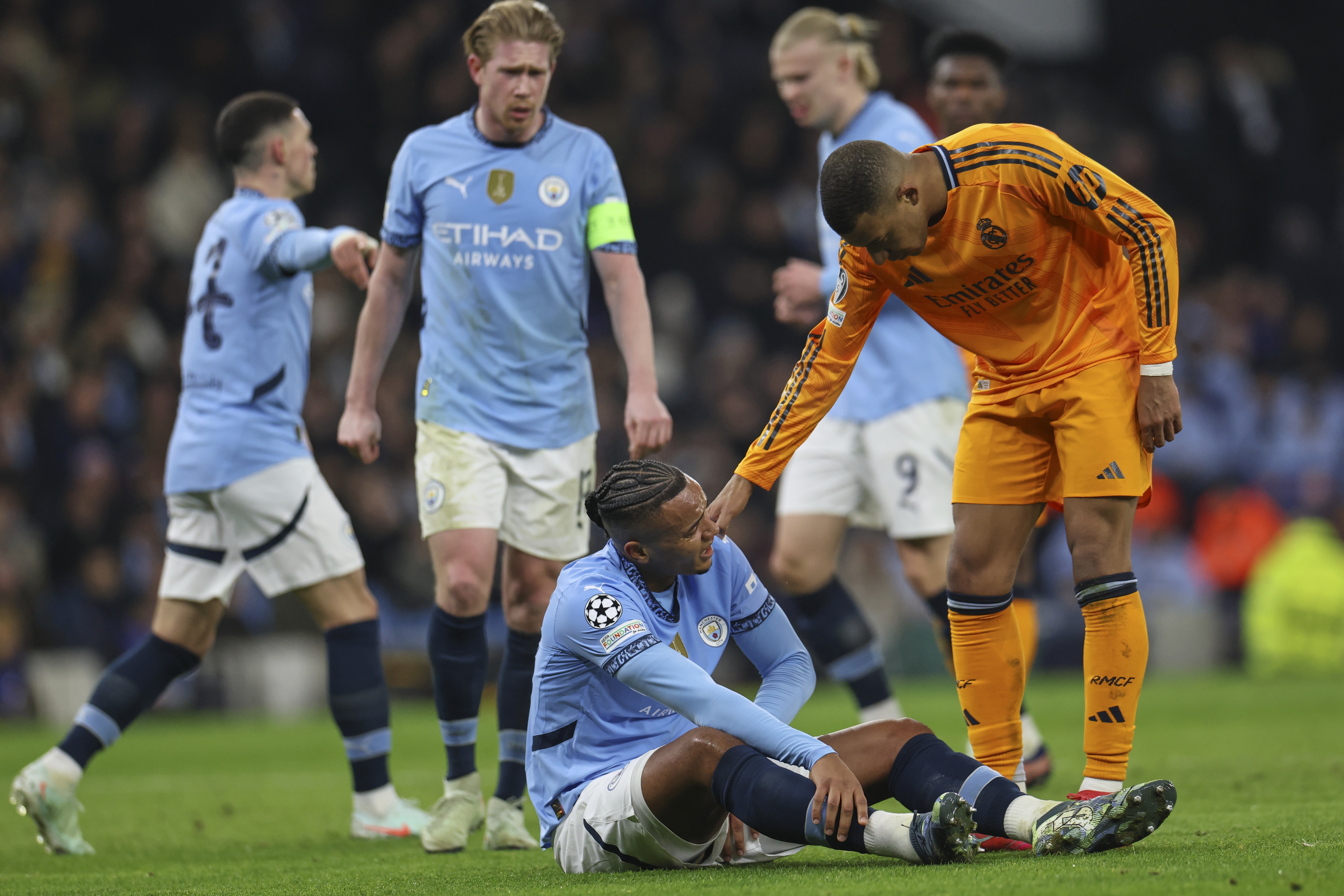 Real Madrid's Kylian Mbappe checks on the condition of Manchester City's Manuel Akanji after he picked up an injury during the Champions League playoff first leg soccer match between Manchester City and Real Madrid at the Etihad Stadium in Manchester, England, Tuesday, Feb. 11, 2025.