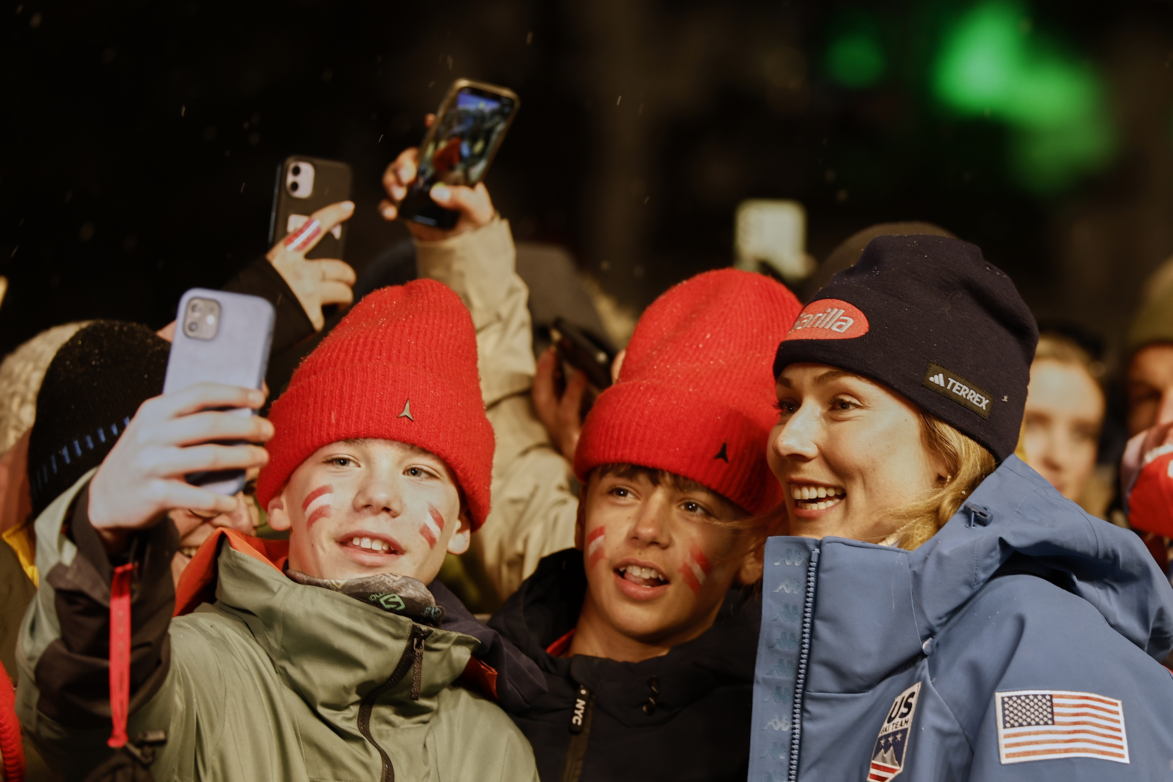 United States' Mikaela Shiffrin, right, poses for selfies with fans at the medal ceremony for a women's giant slalom, at the Alpine Ski World Championships, in Saalbach-Hinterglemm, Austria, Thursday, Feb. 13, 2025. (AP Photo/Gabriele Facciotti