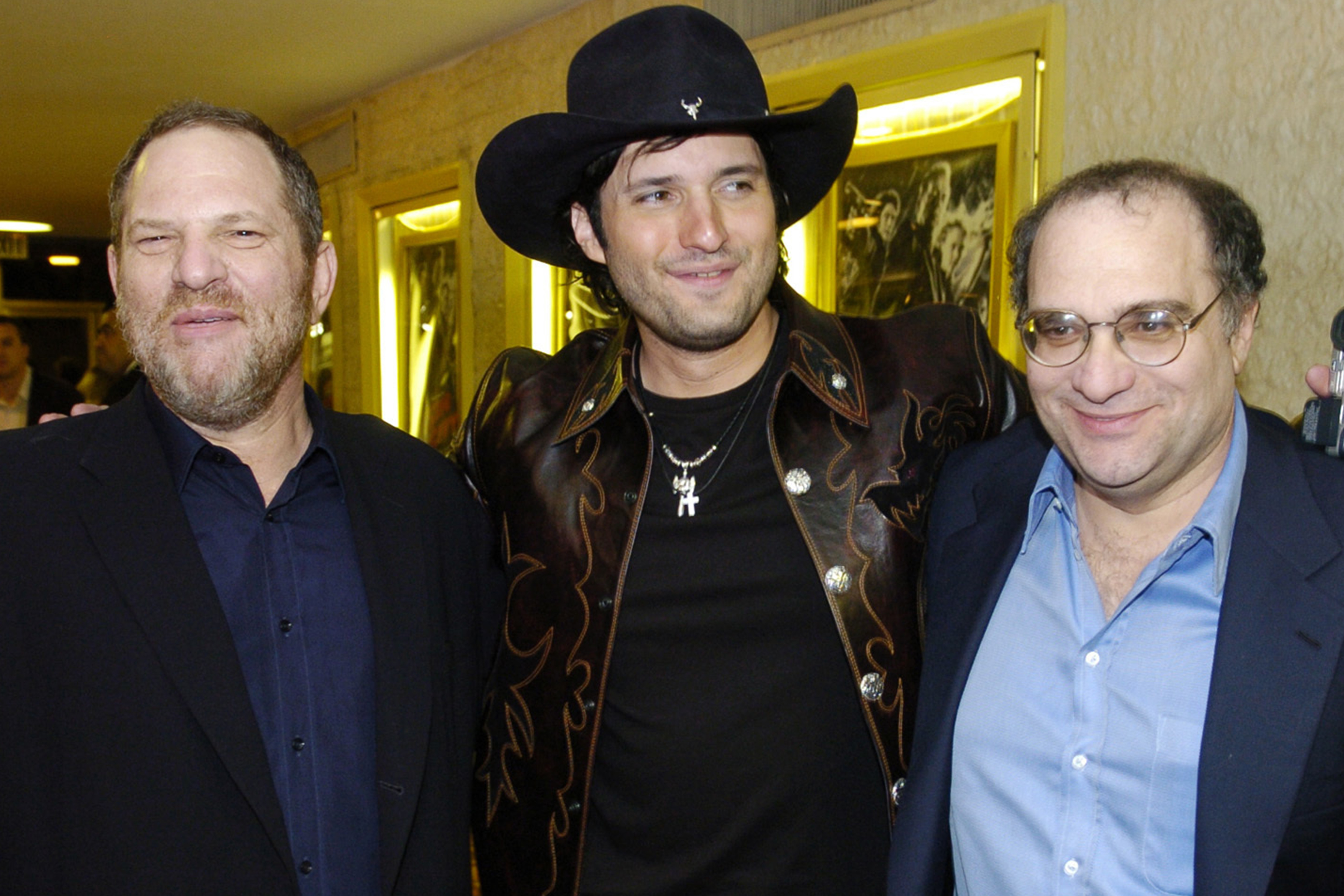 Miramax co-founders Harvey Weinstein, left, and his brother Bob Weinstein, right, pose with "Sin City" co-director Robert Rodriguez, March 28, 2005 in Los Angeles. Harvey Weinstein is suing his brother.