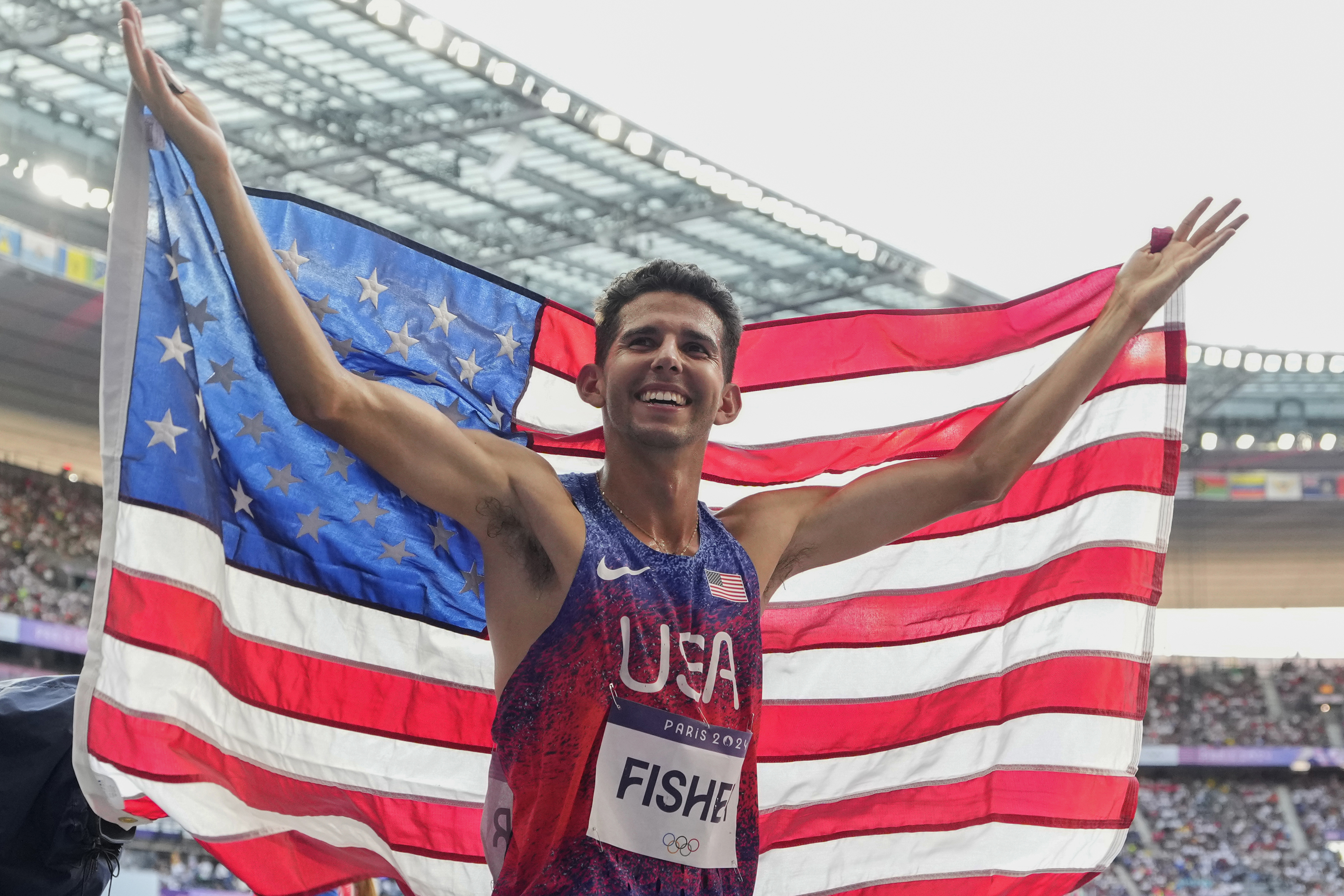 FILE - Grant Fisher, of the United States, celebrates after winning the bronze medal in the men's 5000 meters final at the 2024 Summer Olympics, Aug. 10, 2024, in Saint-Denis, France.