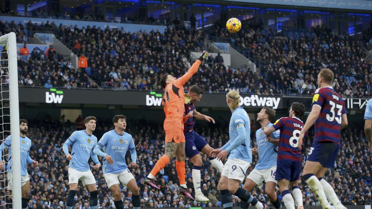 Manchester City's goalkeeper Ederson punches the ball away during the English Premier League soccer match between Manchester City and Newcastle United at Etihad stadium in Manchester, England, Saturday, Feb. 15, 2025.