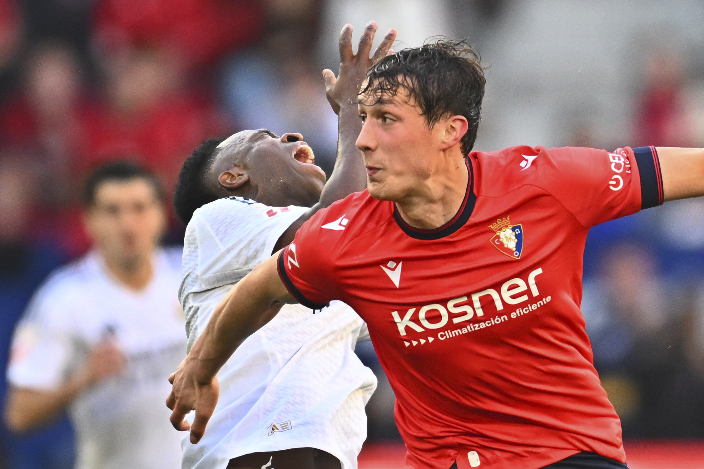 Real Madrid's Vinicius Junior, rear centre, clashes with Osasuna's Jorge Herrando during a Spanish La Liga soccer match between Osasuna and Real Madrid at El Sardar stadium in Pamplona, Spain, Saturday, Feb. 15, 2025.